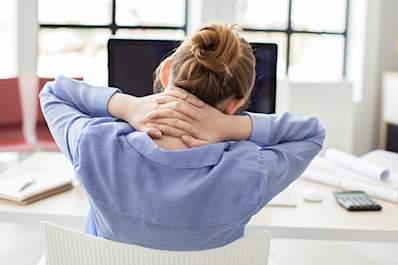 Tired business woman with hands behind her neck.