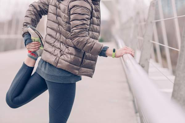 woman stretching in winter gear outdoors