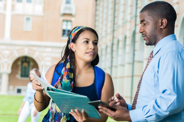 Student talking with professor about scheduling.
