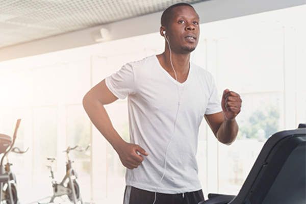 Man running on a treadmill at the gym.
