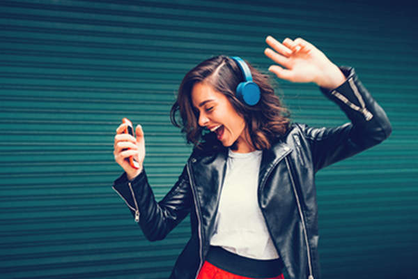 Teen girl dancing with headphones on.