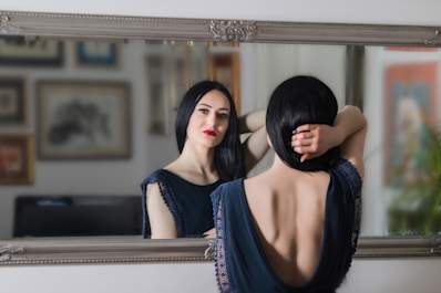 Looking in mirror, body image concept.