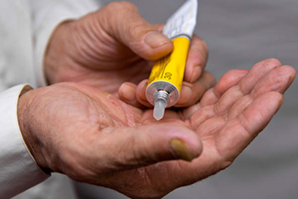 Squeezing a tube of ointment.