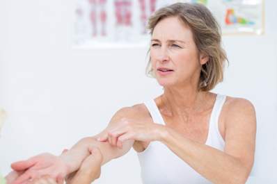 Doctor examining woman's elbow