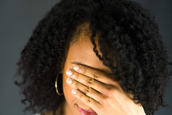 Woman holding her hand on her face.