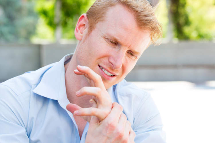 Man holding cramped hand