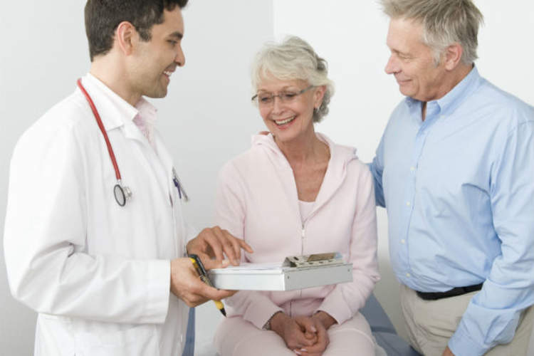 couple going over paperwork with doctor