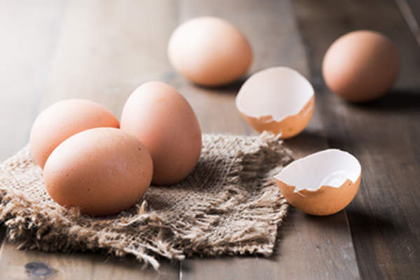 Raw fresh egg on wood background.