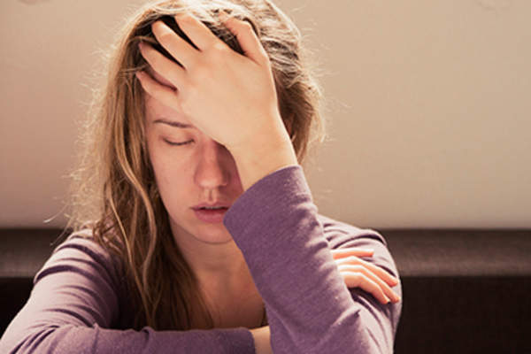 Woman suffering from stress or a headache grimacing in pain