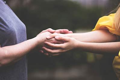 Women holding hands in comfort.