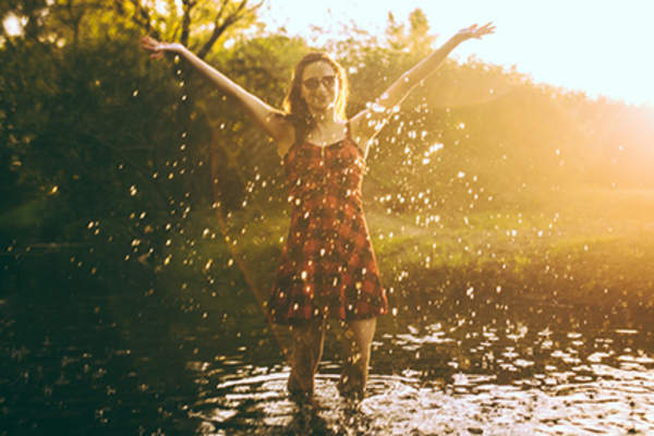 Woman in a plaid dress having fun in water.