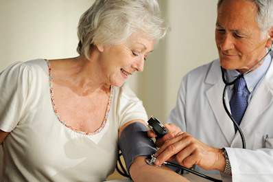 Doctor measuring a senior women's blood pressure.