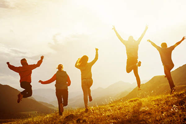People jumping outside in the sun.