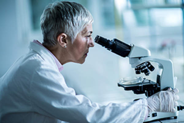 Scientist viewing DNA under a microscope.