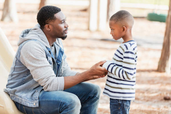Father talks with son on playground.