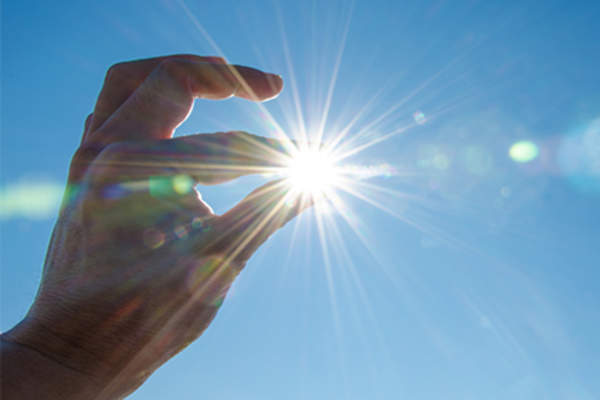 Hand up to the sun and blue sky.