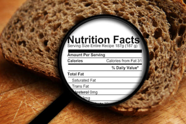 Magnifying glass over bread showing nutrition label.