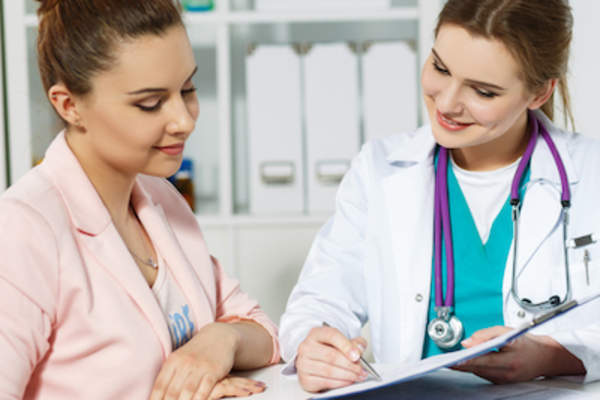 Doctor going over medical paperwork with patient.