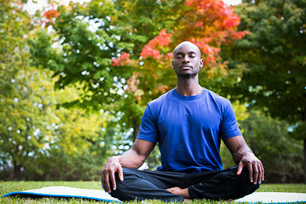 Man meditating in the park.