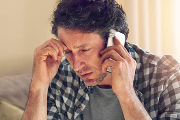 Worried man on phone.