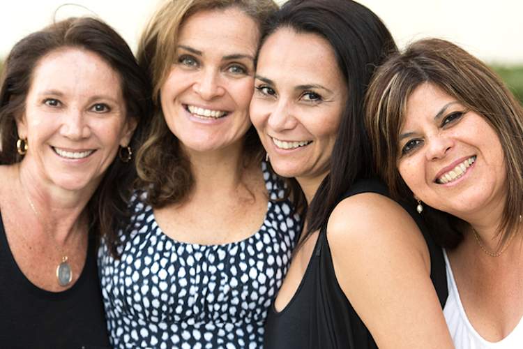 Group of smiling women at a special event.