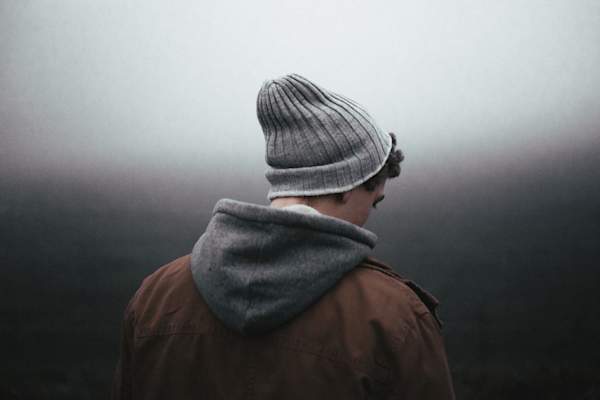 Depressed man in hat looking away