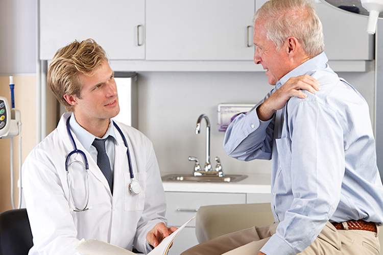 Patient explaining shoulder pain to a doctor.