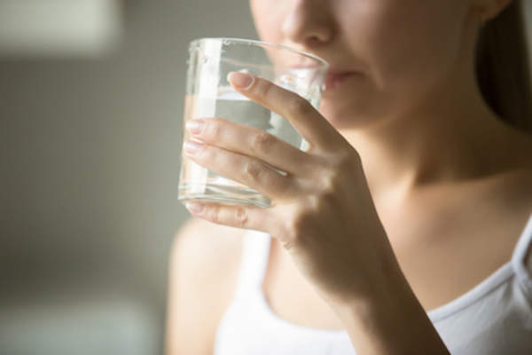 Woman drinking from a glass of water.