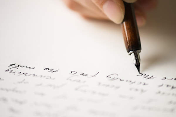 Woman writing letter to friend with fountain pen.