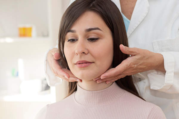 Doctor examining patient's thyroid.