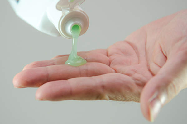 Woman squeezing shampoo into the palm of her hand.