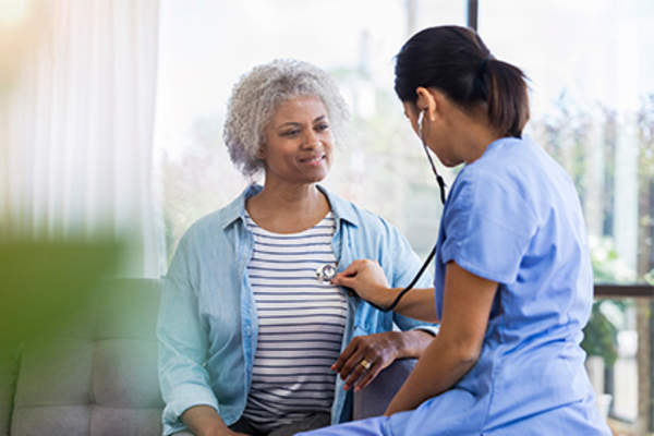 Listening to senior woman's heart with stethoscope.