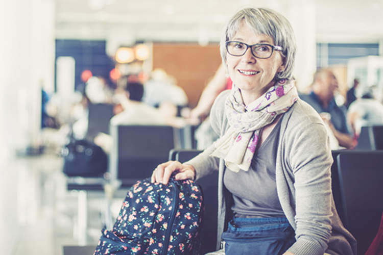 Middle aged woman traveling, waiting in terminal.