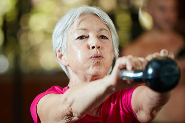 Woman exercising with kettle weight.
