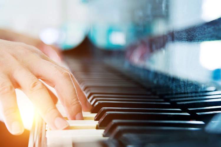 Hands playing piano.