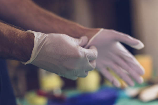 Putting on latex gloves.