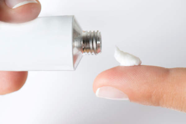 putting topical cream on finger.