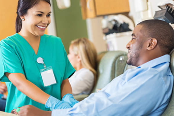 Nurse talking to smiling man in a clinical trial.