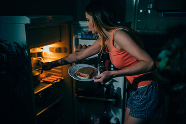 Woman eating at night.