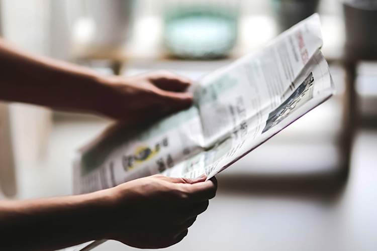 Person reading a newspaper.