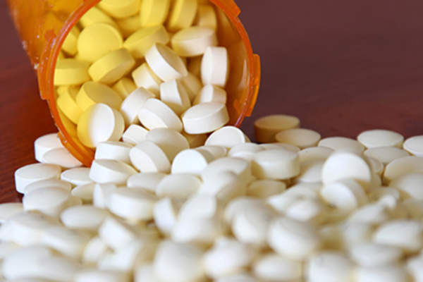 Pills spilling out of a prescription bottle.