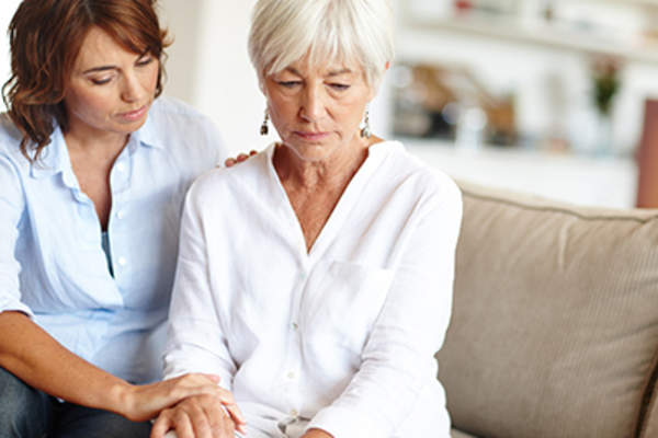 Woman comforting sad senior woman