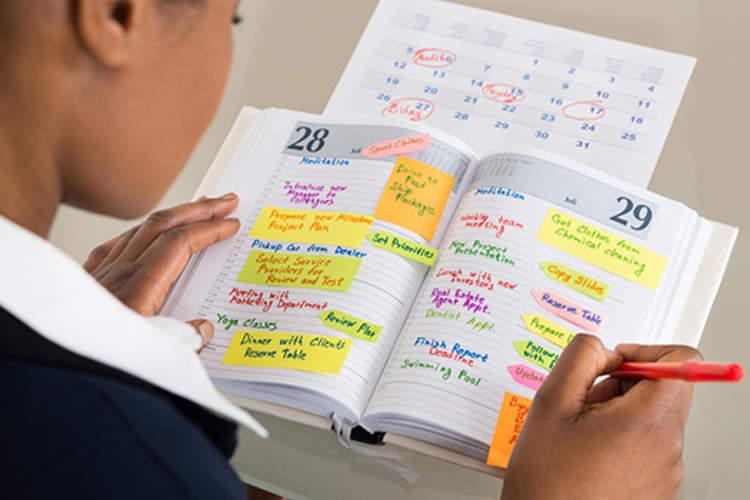 Businesswoman writing in her schedule.
