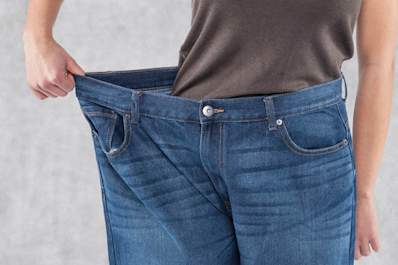 Woman wearing pants that are too big after weight loss.