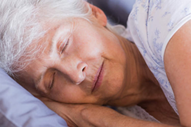 Mature woman sleeping in her bed