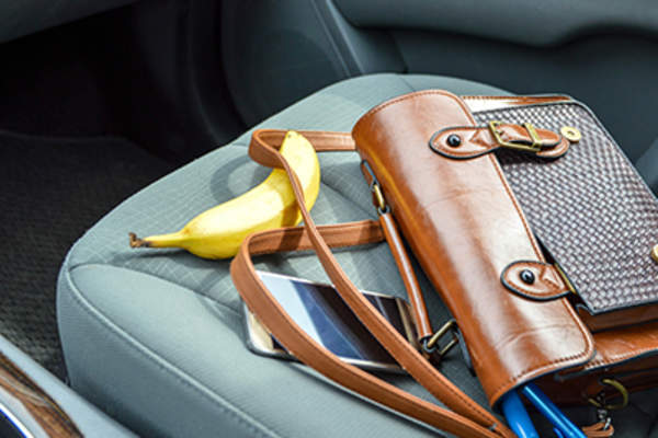 Banana and purse on front seat of car.