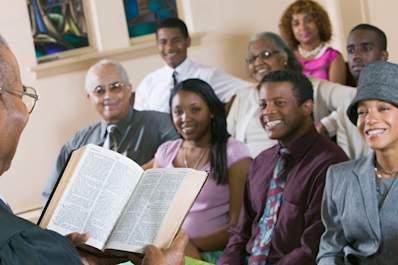 Smiling people in church listening to pastor.