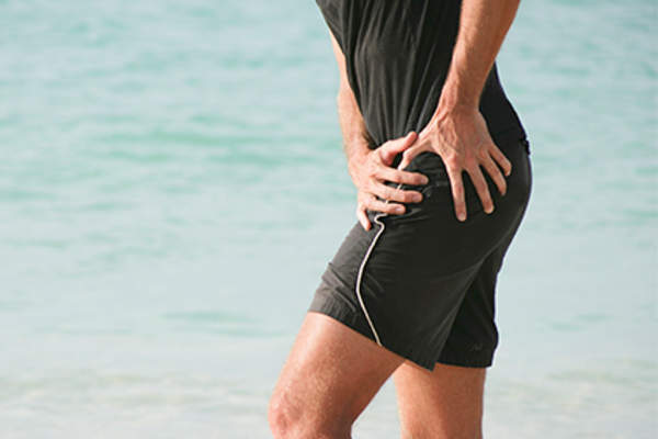 Man holding his left hip.