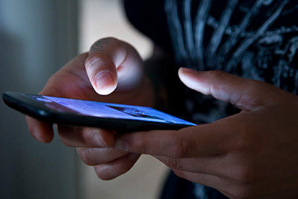 Hands typing on a smartphone.