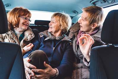Mature women in the back of a car.